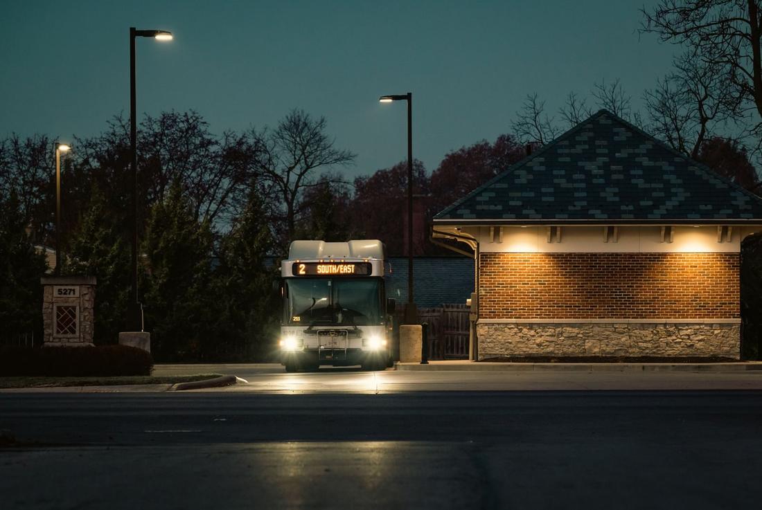 Autobus na przystanku przy wiejskiej drodze o zmroku
